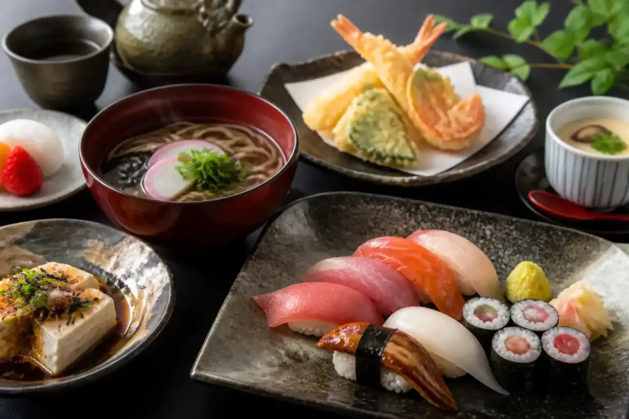 Table japonaise raffinée avec plusieurs plats colorés, ambiance de voyage au coucher du soleil